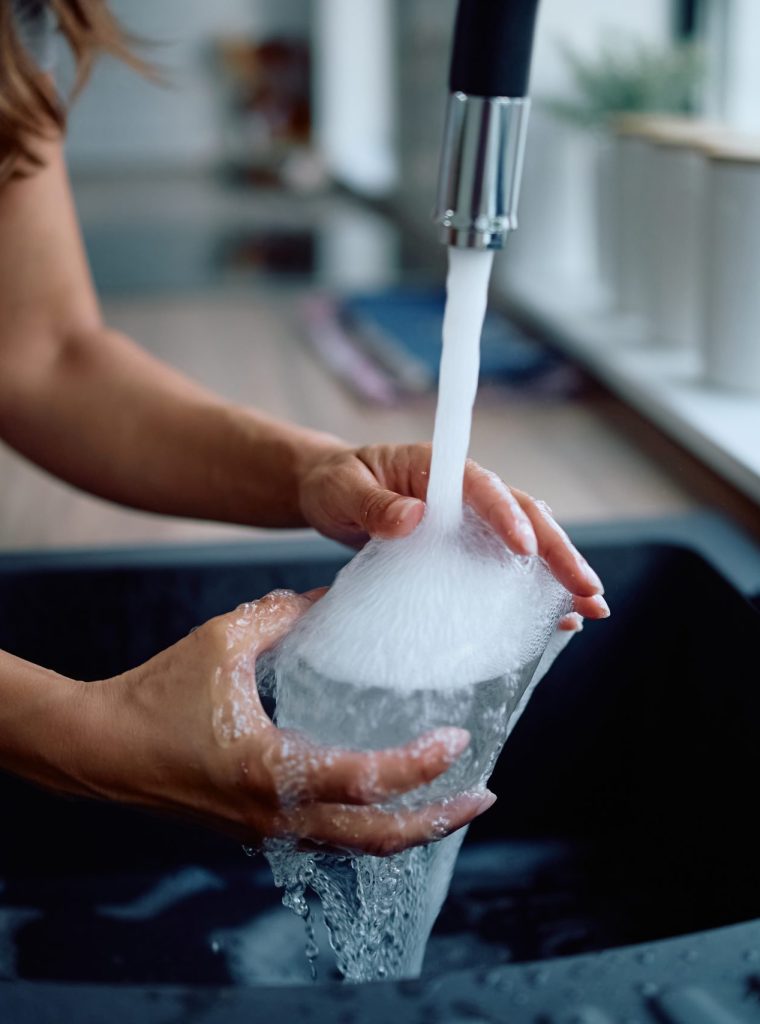 Close up of woman washing dishes in the kitchen.