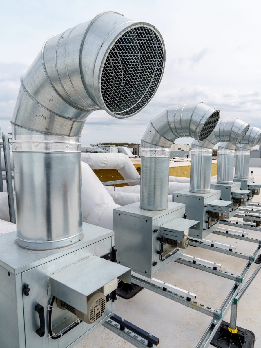 The air conditioning and ventilation system of a large industrial building is located on the roof. It consists of air ducts, air conditioning, smoke removal and ventilation
